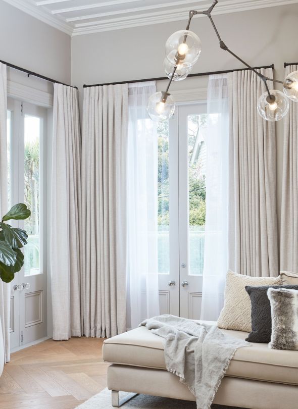 Cosy lounge room with layered curtains.