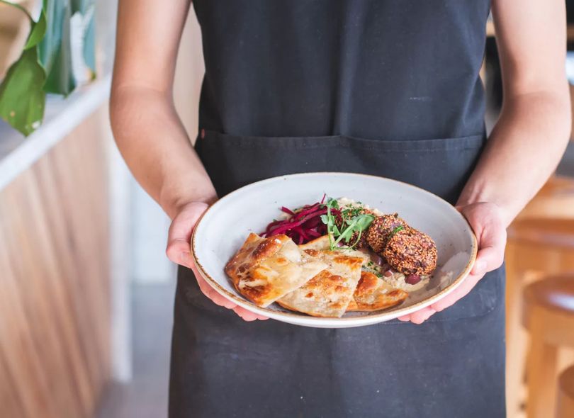 A plate of food being served by staff.