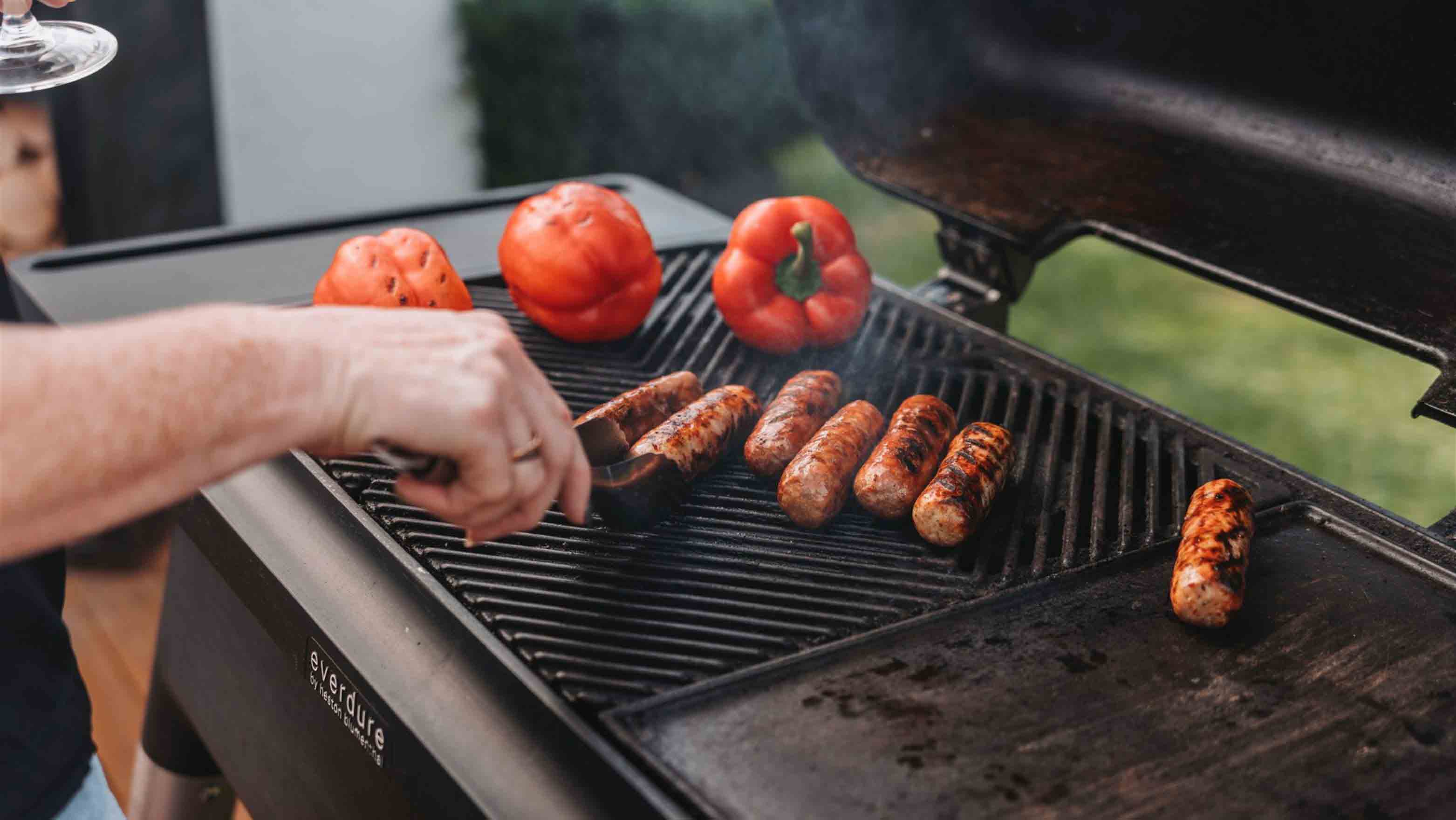 sausages and peppers cooking on gas bbq