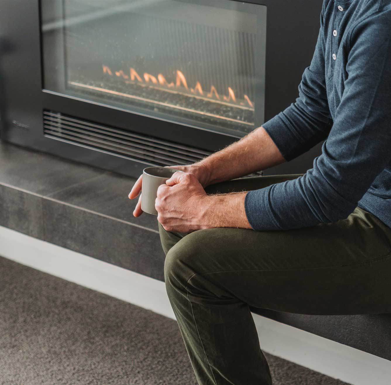 Man sitting in front of a gas fire