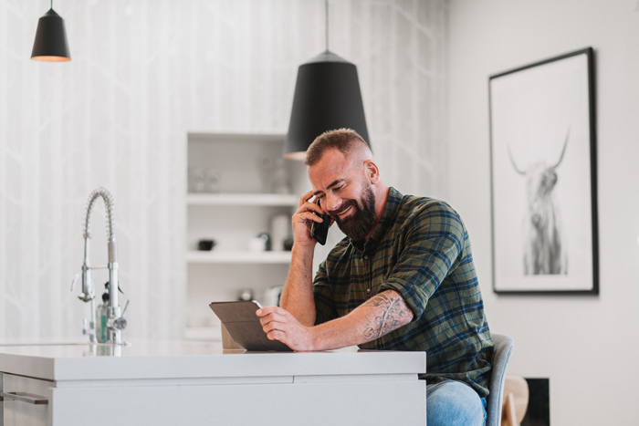 man sitting at kitchen table talking on phone
